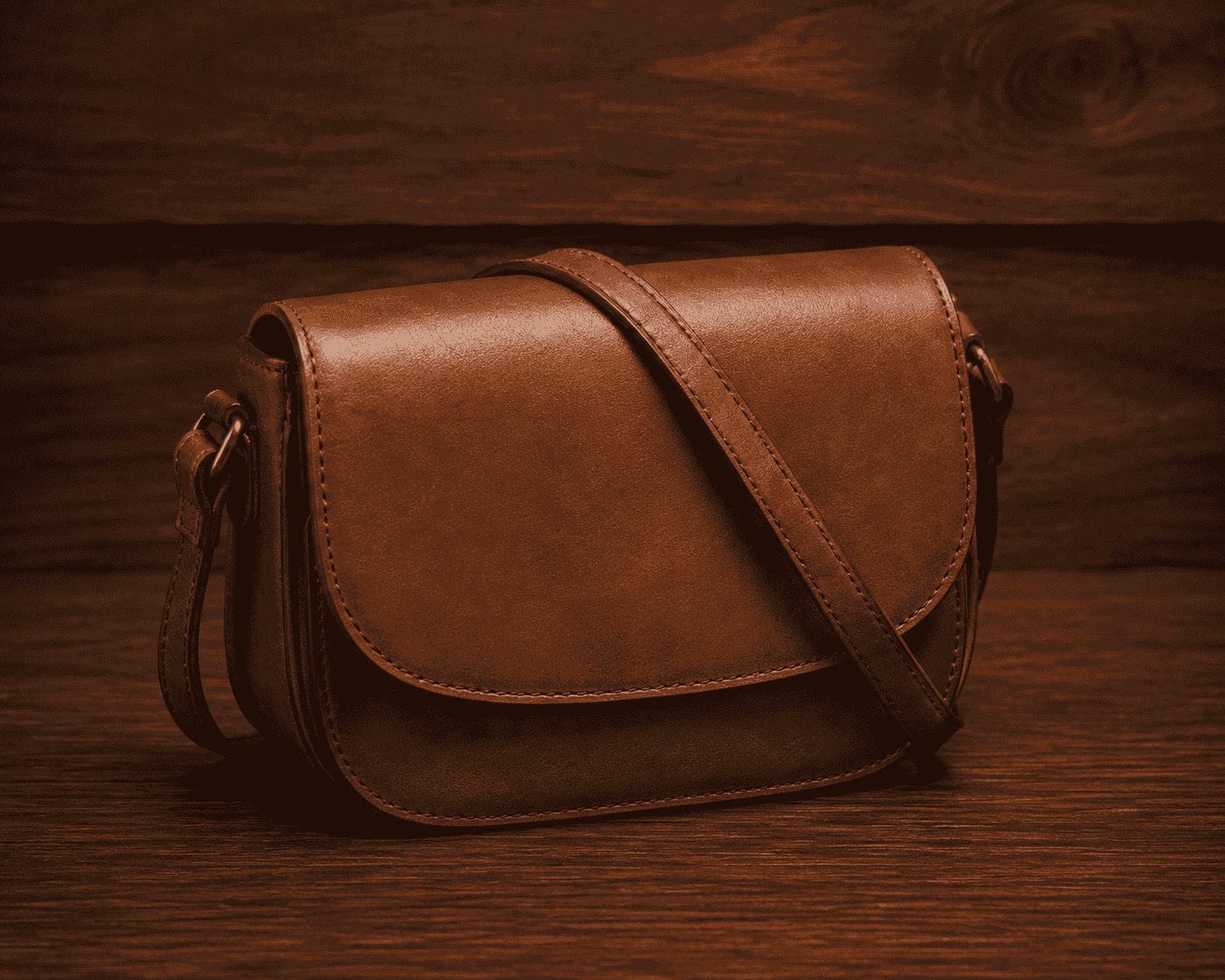 Tan leather flap saddle crossbody bag with shoulder strap